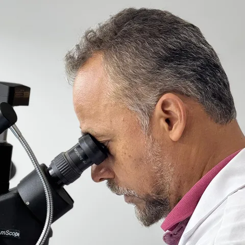 Técnico realizando manutenção de precisão sob microscópio